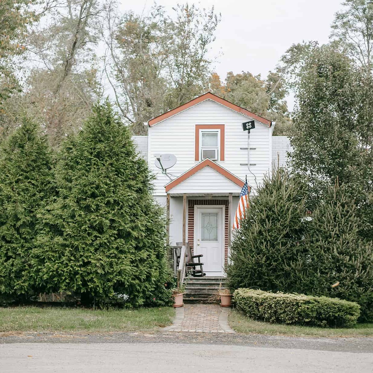 house with overgrown trees in front of entry