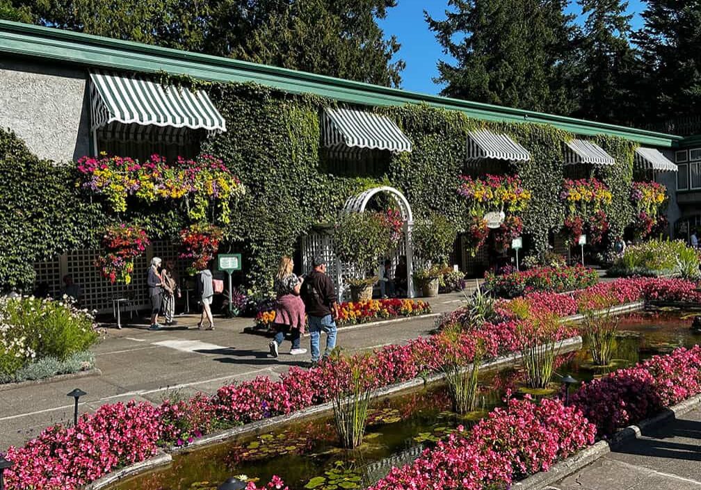 building with striped awnings and colorful rows of flowers in front