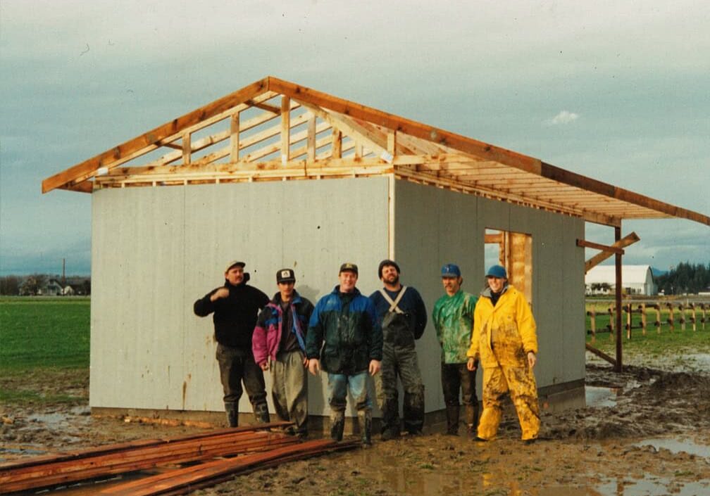 workers standing in front of shed under construction